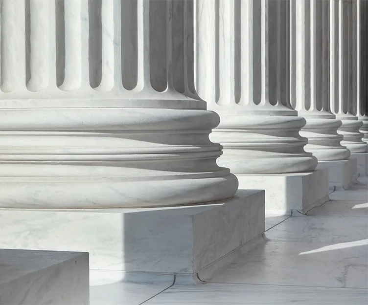 Image of columns in front of a government/official building. Grid analysis and interconnection. Tariff and policy support.